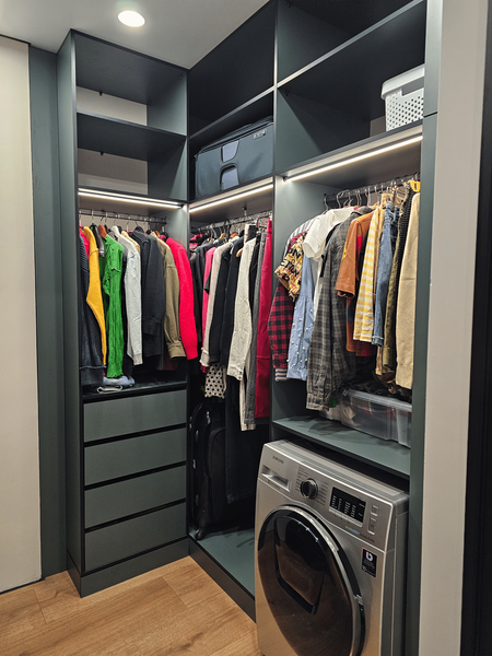 Узкая гардеробная комната с системой хранения по периметру, встроенной подсветкой и зоной для одежды