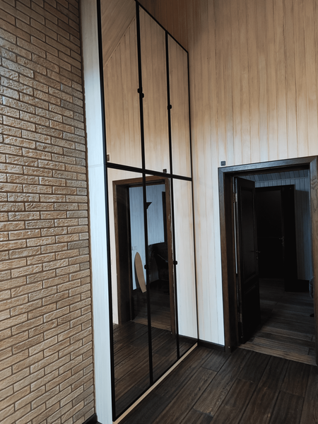 Мансардная гардеробная система с остеклёнными фасадами и чёрным профилем