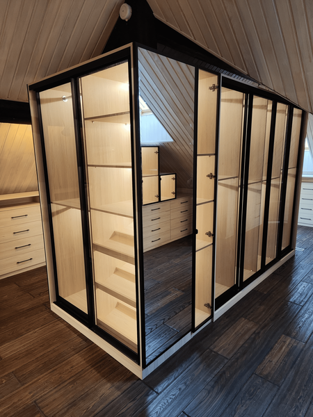 Гардеробная под скатом крыши с остеклёнными шкафами и выдвижными ящиками