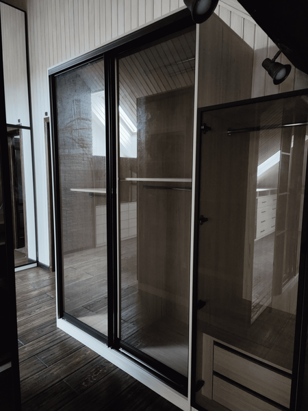 Гардеробная под скатом крыши с выдвижными ящиками и встроенной подсветкой