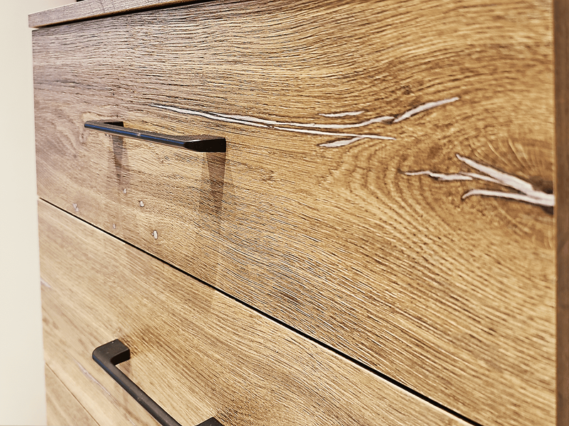 Фрагмент комода гардеробной системы с фасадами под натуральное дерево, подчёркнутой текстурой древесины и металлической фурнитурой в индустриальном стиле