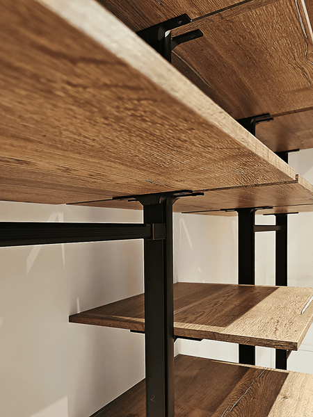 Деталь открытой гардеробной системы: полка под натуральное дерево на металлических опорах чёрного цвета с усиленным креплением, подчёркивающая надёжность конструкции, индустриальный характер и высокое качество исполнения