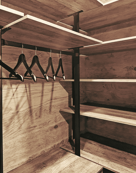 Фрагмент гардеробной системы с полками, металлическими стойками и подвесной штангой для аккуратного размещения одежды