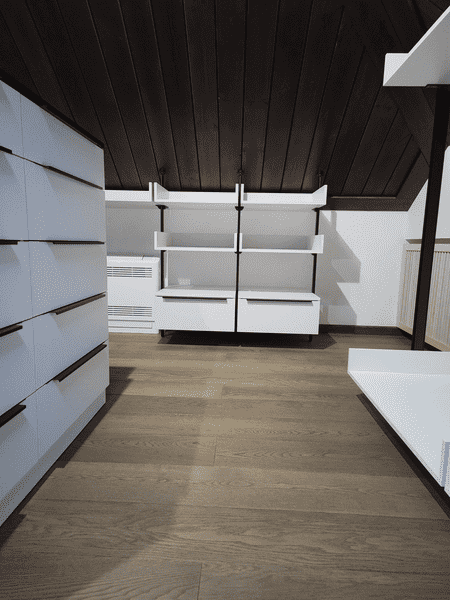 Мансардная гардеробная система с открытыми полками, напольными тумбами и адаптацией конструкции под наклон потолка