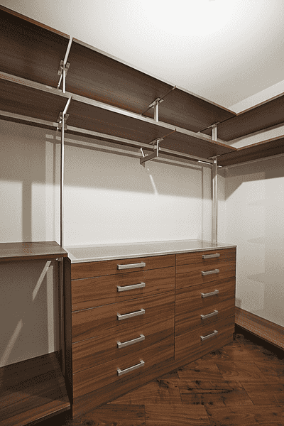 Гардеробная система с деревянными полками, металлическими стойками, центральным комодом и рабочей поверхностью по периметру