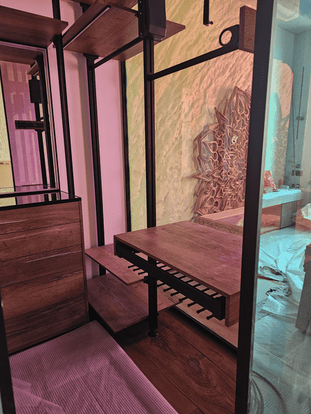 Функциональный модуль гардеробной с выдвижной брючницей и рабочей поверхностью, чёрный металлический каркас, тёплая древесная текстура