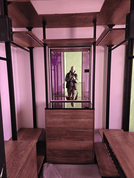 Общий вид гардеробной комнаты с центральным комодом, боковые секции с полками и зонами хранения, продуманная симметрия и интеграция зеркала