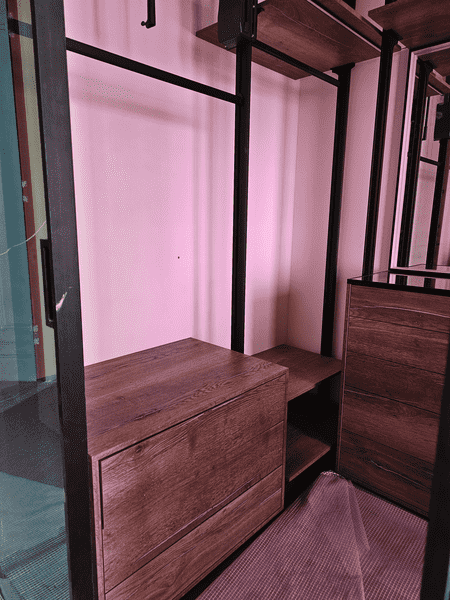 Угловой модуль гардеробной с выдвижными ящиками и полками, чёрный каркас, тёплый оттенок древесины, рациональное использование пространства