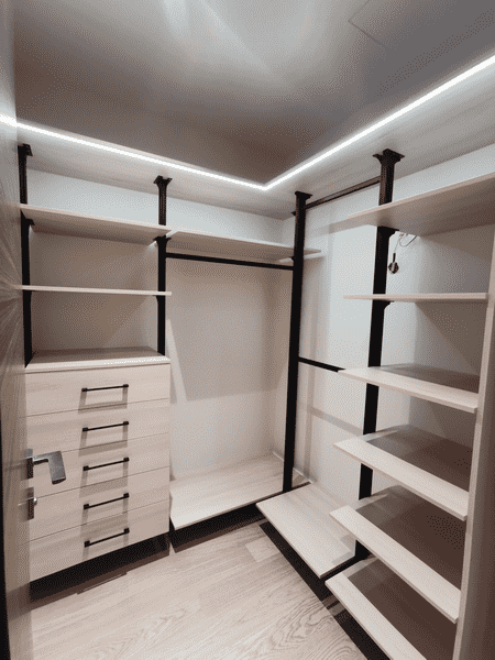 Светлая гардеробная комната с подсветкой, металлическими стойками и открытыми полками