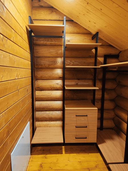 Гардеробная система в мансардном помещении с деревянными стенами и комбинированными модулями хранения