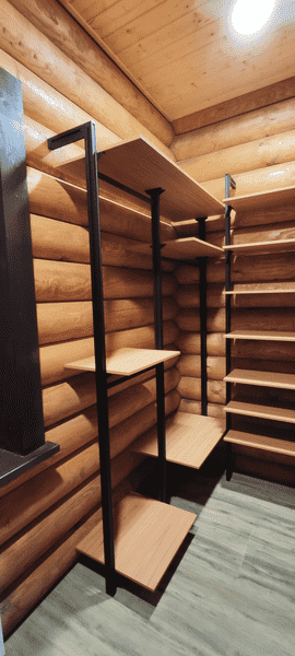 Открытая гардеробная система с полками и зонами для хранения одежды, адаптированная под деревянный интерьер дома. Гардеробная на заказ обеспечивает удобную организацию пространства без потери полезной площади.