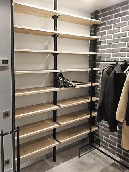 Открытая гардеробная система с полками и штангами вдоль стены. Гардеробная комната в современном индустриальном стиле.
