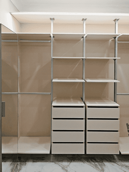 Функциональная гардеробная система с открытыми секциями и ящиками для одежды. Гардеробная комната, адаптированная под индивидуальные размеры помещения.