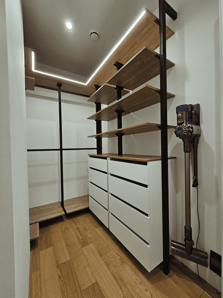 Гардеробная система с металлическими стойками, полками и ящиками белого цвета. Современная гардеробная комната с продуманной эргономикой.