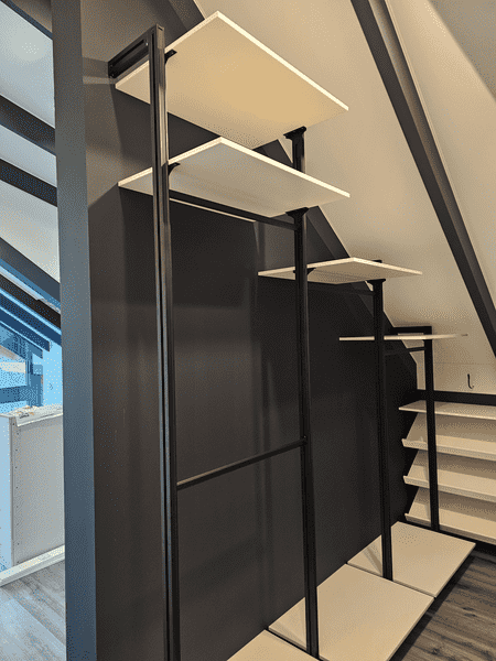 Открытая гардеробная система в мансардном помещении. Гардеробная на заказ с учетом наклонных стен и освещения.