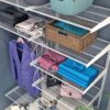 Близкий план металлических полок с аккуратно сложенной одеждой и коробками
