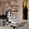 Система хранения в гостиной с корзинами и одеждой на вешалках